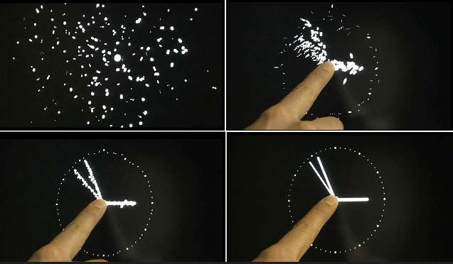 Eric Morzier: Horloge tactile, horloge murale, 2005  (© Éric Morzier / SIGMASIX / ECAL) A screen displays a cloud of points that move randomly, but when it is touched the points gather to form a clock, until it is released and the points resume once again their random paths. Artist Eric Morzier says that the ephemeral formation of the clock reminds us that time continues inexorably.